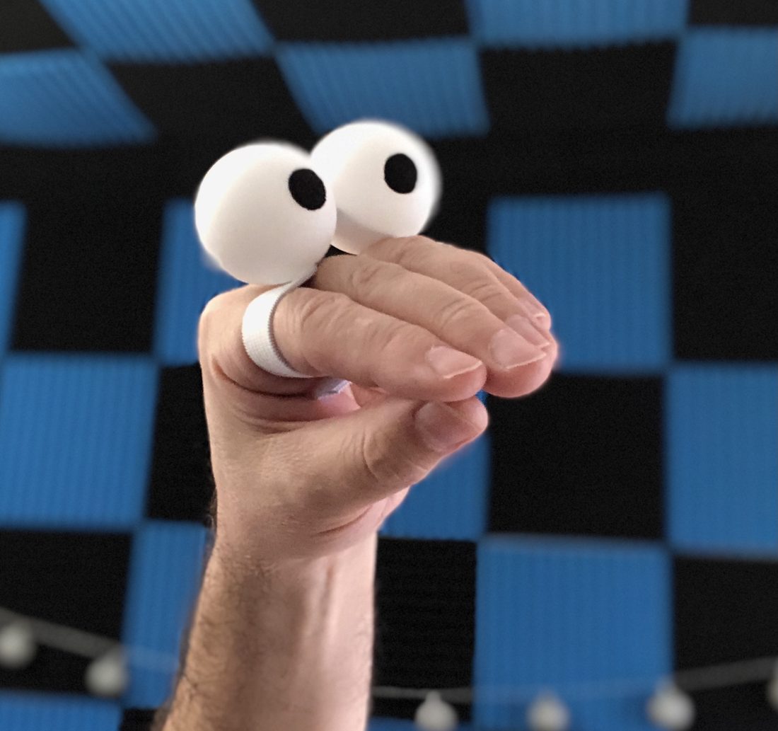 A puppeteer's hand wearing a simple pair of character eyes